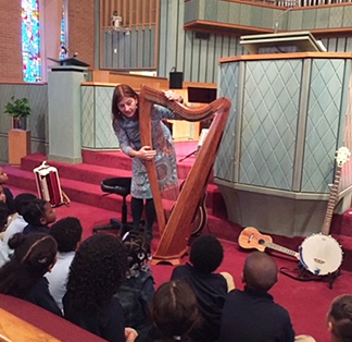Teacher showing students how to play harp