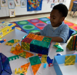 Boy in classroom building with shapes