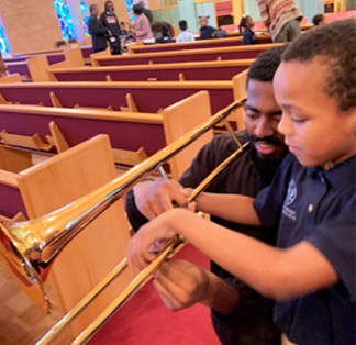 Elementary student learning how to play a horned instrument